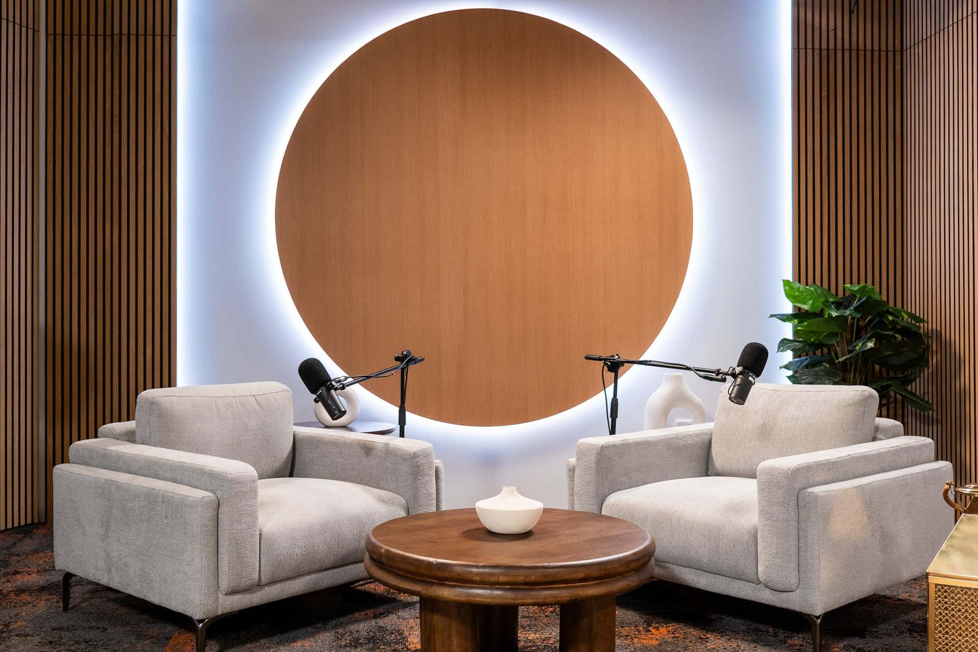 Orbit Set – Iconic Podcast Studio with Glowing Circular Backdrop & Wood Paneling - Podcast Space in Dubai
